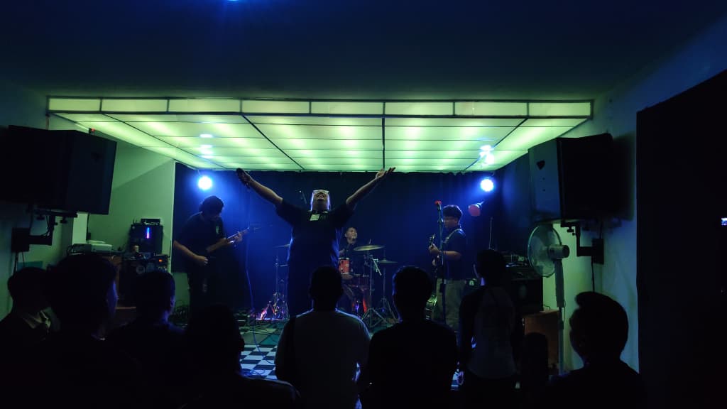 Sayap Lepas performing under stage lights